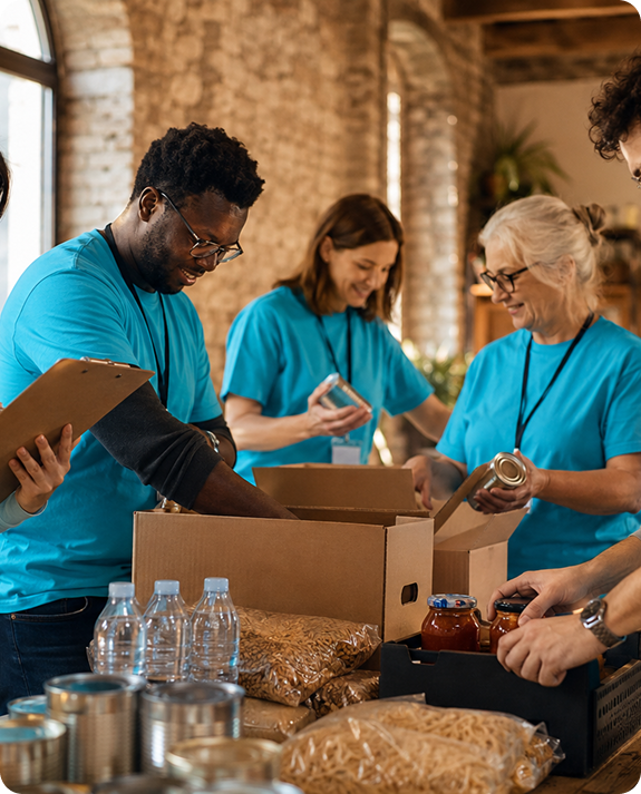 Volunteers in blue shirts packing food donation boxes